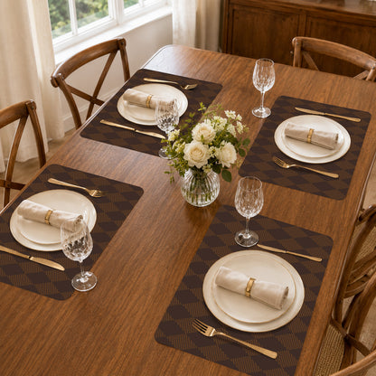 Brown argyle silicone placemats styled on a wooden dining table with plates, napkins and glassware.